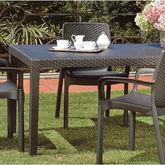 Mesa retangular IPAE PROGARDEN em plástico, de cor cinzenta, com ranhuras e acabamento trançado e 4 pés de suporte. Exibido em ambiente exterior.